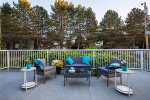 a patio with couches and tables and a fence at Spacious and Comfy ! in Victoria