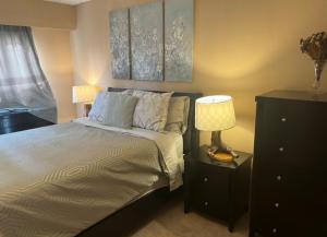 a bedroom with a bed with two lamps and a dresser at Spacious and Comfy ! in Victoria