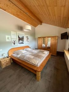 uma cama grande num quarto com tecto em madeira em Ferienwohnung Reifferscheid em Hellenthal