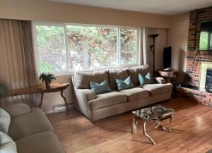 a living room with a couch and a fireplace at Spacious and Comfy ! in Victoria