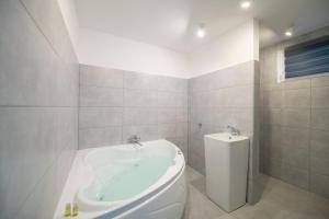 a bathroom with a toilet and a bath tub at Pixel Guesthouse in Târgu Secuiesc +106 photos