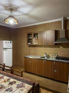 a kitchen with wooden cabinets and a white refrigerator at Irina in Tskaltubo