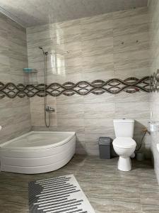 een badkamer met een wit bad en een toilet bij Irina in Tskaltubo