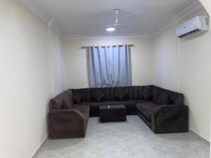 a living room with a brown couch in a room at Red-15 - Bn Saif in Salalah