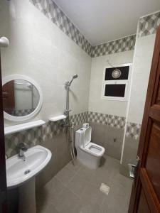 a bathroom with a sink and a toilet and a mirror at Red-15 - Bn Saif in Salalah