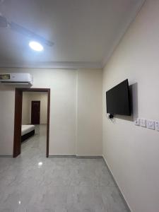 a room with a flat screen tv on a wall at Red-15 - Bn Saif in Salalah