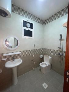 a bathroom with a sink and a toilet and a mirror at Red-15 - Bn Saif in Salalah