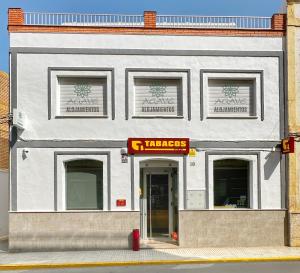 a white building with a pharmacy sign on it at ALOJAMIENTOS AGAVE in Tabernas