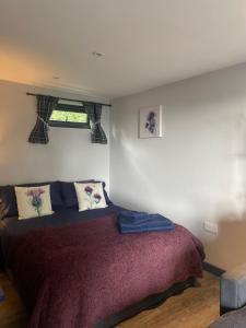 una camera da letto con un grande letto con lenzuola viola di Little bay cabin a Oban