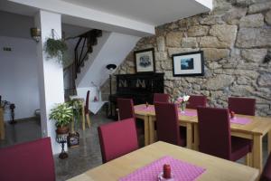 a dining room with a table and chairs and a stone wall at Quinta Calcaterra in Marialva