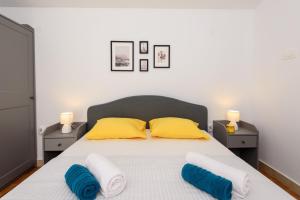 a bedroom with a bed with yellow and blue pillows at Holiday Home Laumar in Klek