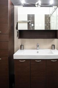een badkamer met een witte wastafel en een spiegel bij PS Unique Experience in Nafplio