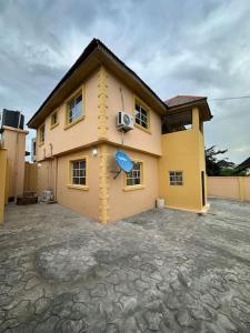 una casa con un orologio sul lato di 3 Bedrooms Duplex a Ibadan
