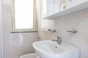 a white bathroom with a sink and a mirror at Affittacamere Bellavista in Castiglione di Sicilia