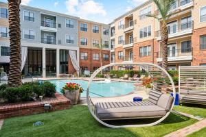 a hammock in a yard with a pool in a apartment at Hot Spot Loft mins from Galleria in Houston