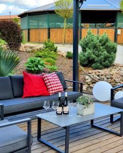 a patio with a couch and a table with wine glasses at Agroturystyka BM Horse 