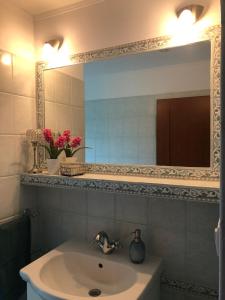 ein Bad mit einem Waschbecken und einem Spiegel in der Unterkunft Rodinný apartmán Villa Familia in Bojnice