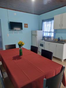 a kitchen with a table with a red table cloth at Alojamiento Los Imigrantes in Chajarí