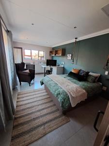a bedroom with a bed and a living room at Greenhouse in Boksburg