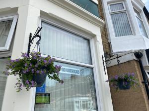 a no worries sign in a window with purple flowers at The Laurels in Blackpool