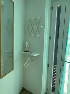 a bathroom with a mirror and a shelf with hangers at Casa del Capitano - Suite Mediterraneo in Ponza