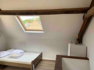 niewielka sypialnia z łóżkiem i oknem w obiekcie 2pas2meuse w mieście Waulsort