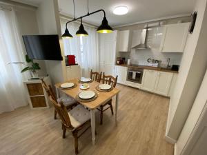 a kitchen with a wooden table and chairs in a kitchen at Apartamento La Duna de Gamazo en Santander in Santander