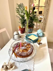 a table with a cake on a glass plate with a candle at Residenza Elisa in Desenzano del Garda