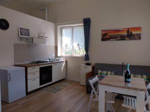 a kitchen and dining room with a table and a table and a window at Casa Elly in Riva di Solto