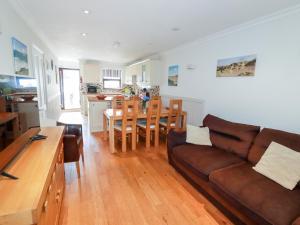a living room with a couch and a dining room at The Dunes in Crantock