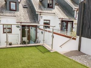 a house with a balcony with a yard at The Dunes in Crantock