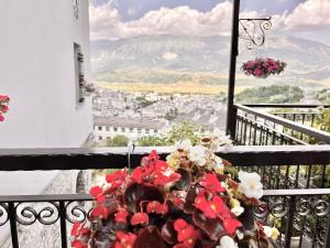 a vase of flowers on a balcony with a view at Boutique Hotel Musée in Gjirokastër