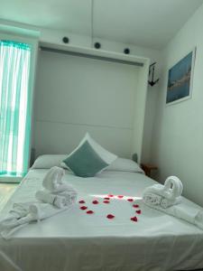 a bed with towels and red hearts on it at Casa del Capitano - Suite Mediterraneo in Ponza