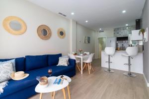 un soggiorno con divano blu e una cucina di Apartamento Salinas a Fuengirola