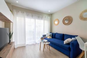 un divano blu in soggiorno con finestra di Apartamento Salinas a Fuengirola
