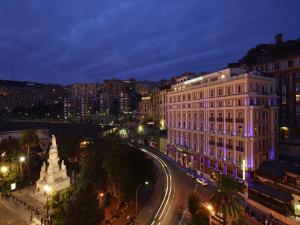a view of a city at night with a building at Grand Hotel Savoia in Genoa