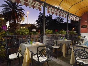 an outdoor restaurant with tables and chairs and avisor at Grand Hotel Savoia in Genoa