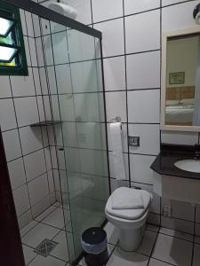 uma casa de banho com um WC e uma cabina de duche em vidro. em Quinta Da Bica D'Agua Village em Florianópolis