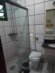 a bathroom with a toilet and a glass shower at Quinta Da Bica D'Agua Village in Florianópolis