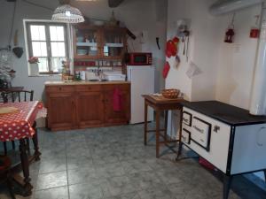 a kitchen with a table and a sink and a refrigerator at Harmat Porta in Galambok