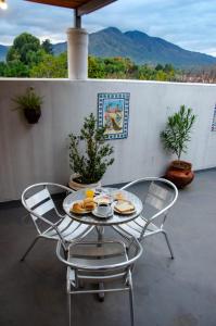 a table with two chairs and a plate of food on it at Posada Del Arbol in Capilla del Monte