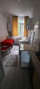 a kitchen with a stove and a table in a room at Apartament La Denis in Bîrlad