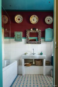 W łazience znajduje się umywalka, wanna i lustro. w obiekcie Les Jardins Haute Couture w mieście Huismes