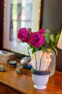 una mesa con un jarrón lleno de rosas rosas y un jarrón lleno de en Les Jardins Haute Couture en Huismes