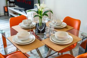 a dining room table with plates and glasses on it at Ashview 8 - Heathrow - Business - Free Parking in Staines upon Thames