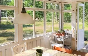 - une salle à manger avec des fenêtres, une table et des chaises dans l'établissement Amazing Home In Frjestaden With Kitchen, à Färjestaden