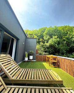 a backyard with a wooden deck and a table and chairs at Casa Honey in Liège