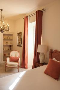 um quarto com uma cama, uma cadeira e uma janela em L'Abbaye Hôtel em La Colle-sur-Loup