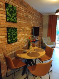 uma mesa e cadeiras num quarto com uma parede de tijolos em Apartament Mech & Paprocie em Ustrzyki Dolne