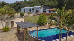 a swimming pool with a table next to a building at Pousada Kart Clube in São João del Rei